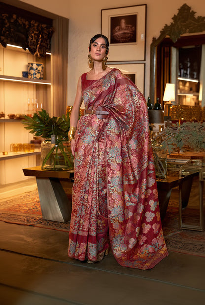 Woman wearing a floral saree in an indoor setting with decor elements.