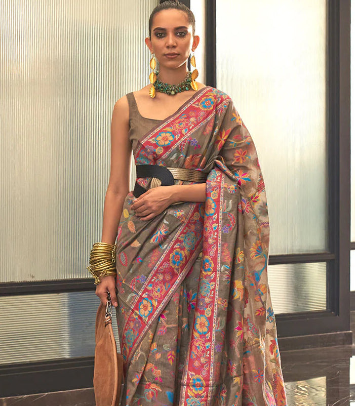 Woman wearing a colorful saree with a patterned background