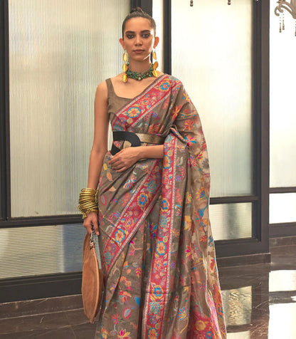Woman wearing a colorful saree with a patterned background