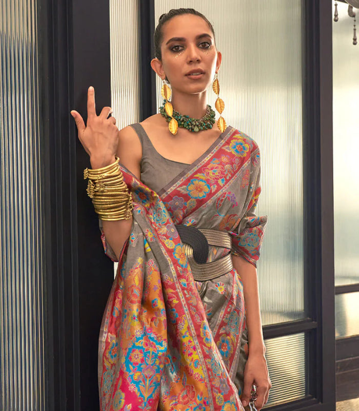 Woman wearing a colorful saree with a patterned design indoors.