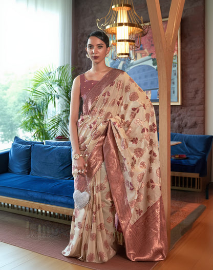 Woman in a floral saree standing in an indoor setting with decor elements.
